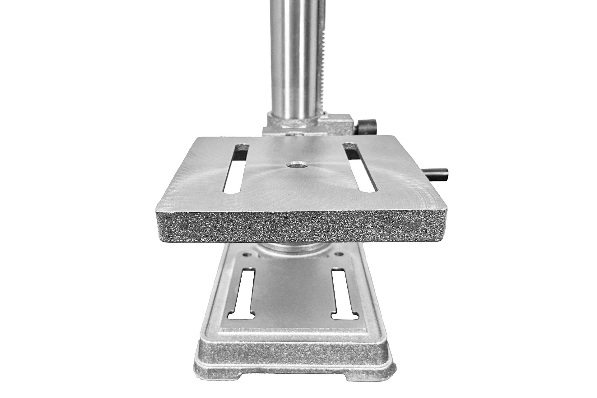 Detailaufnahme Radialbohrmaschine: Metalltisch mit T-Nuten und zentralem Loch, montiert auf Metallsäule und Basis. Graustufen.